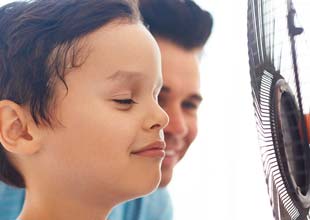 Boy cooling off with fan