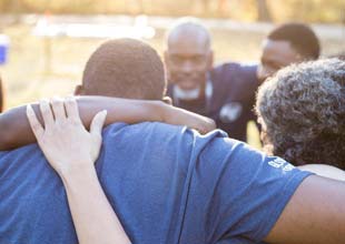 People in community hugging each other