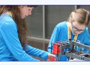 Girls building a robot in a STEM classroom
