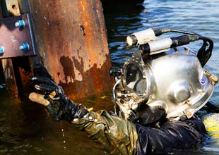 Scuba diver screwing bolts under water
