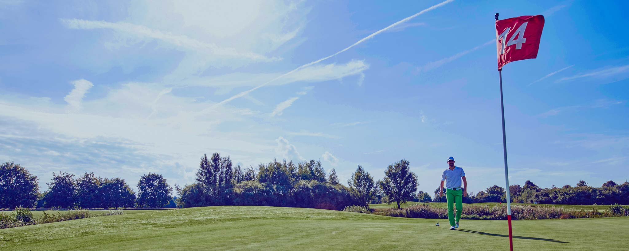 Golfer playing golf, near 14th hole