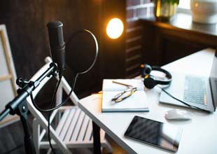Audio studio with laptop, microphone with pop filter and headphones