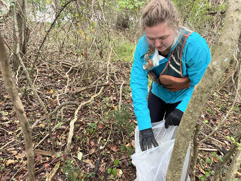 Volunteer filling a trash bag