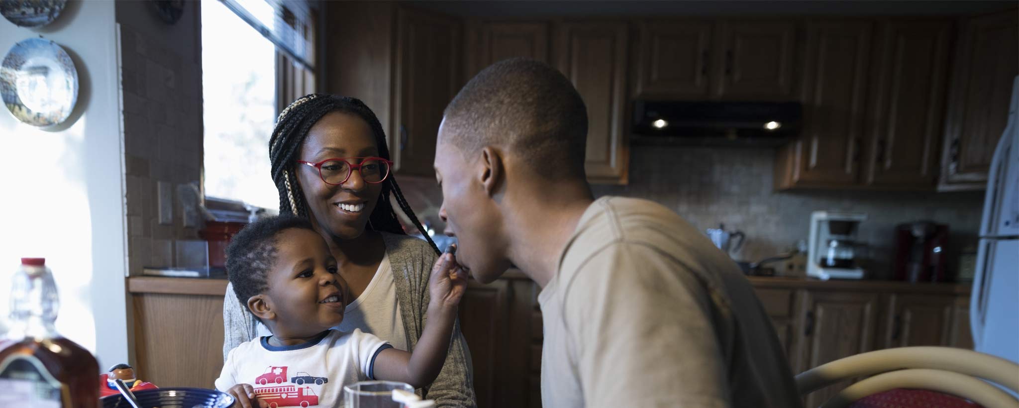 Family of three sitting at dining table in house