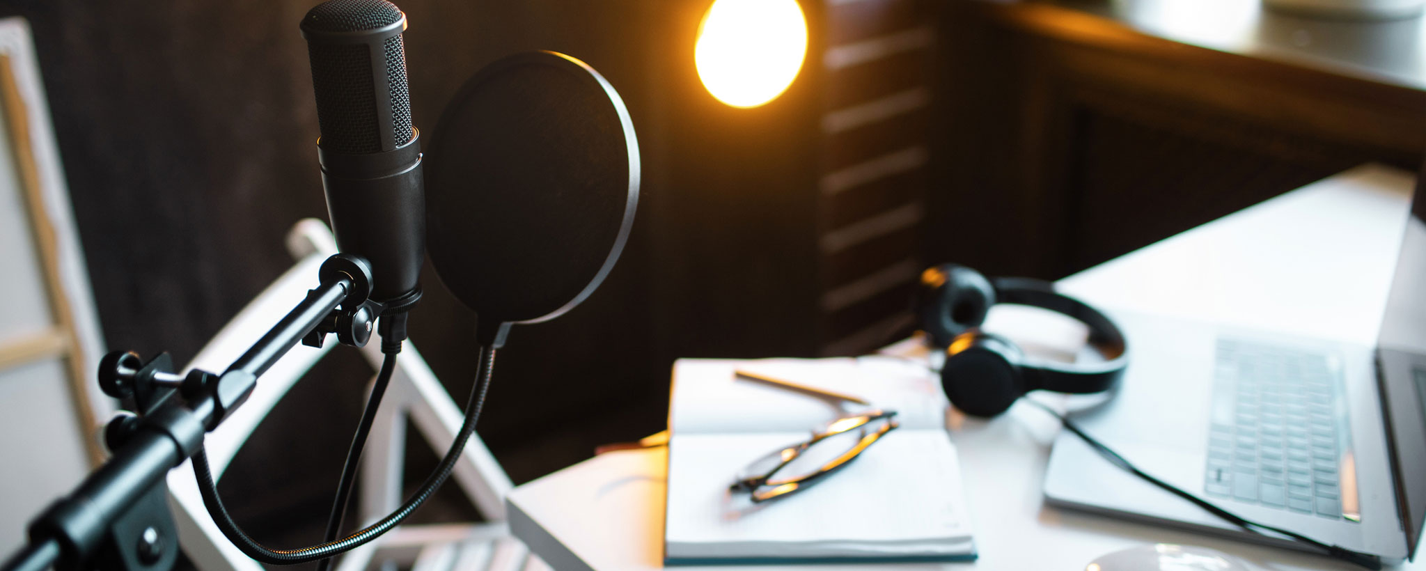 Audio studio with laptop, microphone with pop filter and headphones