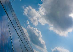 Solar Panels on roof top with blue sky and clouds
