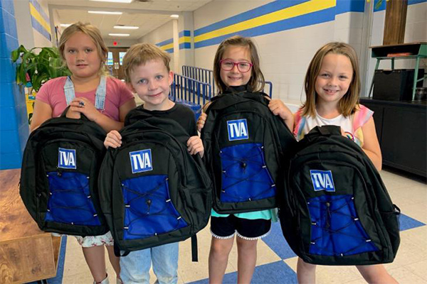 children holding TVA backpack