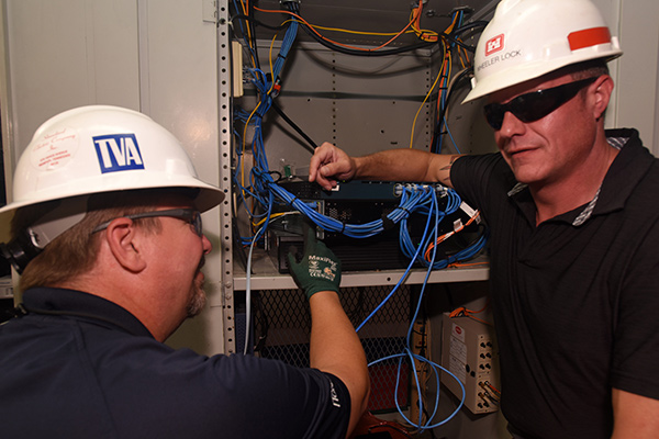 Engineers Rich Ellis and Bradley Gatewood connect fiber optic cables to boost data speed at Joe Wheeler Lock.