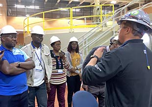 Plant Manager gives Uganda guests a tour of plant